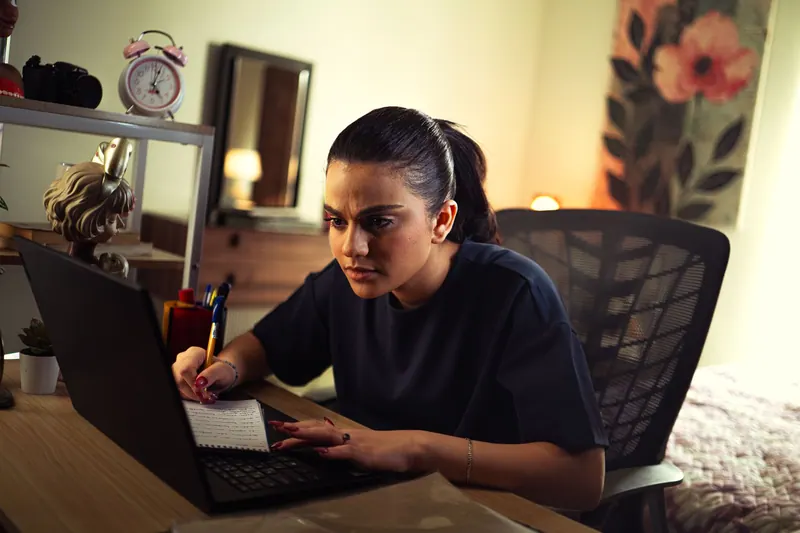 Studentin lernt zu Hause mit Laptop und Notizen