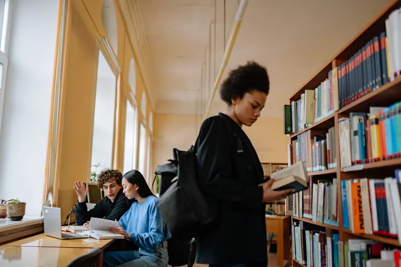 Studierende diskutieren in einer Bibliothek über sozialwissenschaftliche Fragen